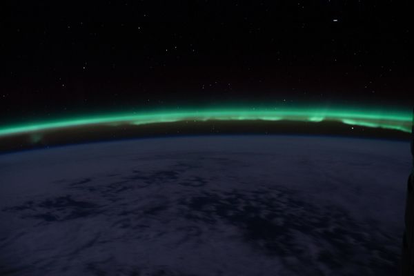 The 'aurora australis' hovers above the Earth's horizon